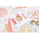 Die Sizzix 666230 Thinlits Fabulous Birthday Numbers von Debi Potter bieten pastellfarbene und goldene Akzente, ideal für Scrapbooking und handgefertigte Grußkarten, die alle wunderschön auf einer weißen Oberfläche dargestellt werden.
