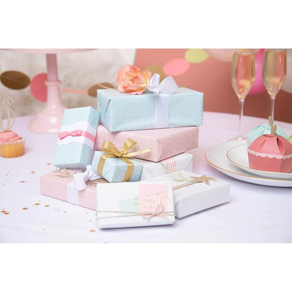 Ein Stapel rosa und blauer Geschenkboxen auf einem Tisch, personalisiert mit Sizzix • Thinlits Die Set Fabulous Family Names von Debi Potter und verziert mit Fabulous Birthday Numbers.