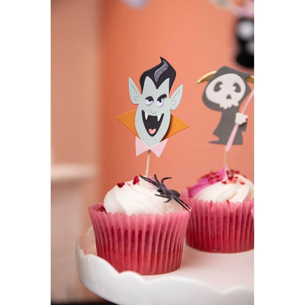 Halloween-Figuren Sizzix Dracula Cupcake-Topper auf einem weißen Teller.