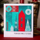 Versenden Sie Weihnachtsstimmung mit einer Karte, die mit den Sizzix 666335 Thinlits Stanzschablonen Holiday Blocks von Sizzix erstellt wurde. Die Karte zeigt geometrische Bäume in Rot, Petrol und Weiß und den Gruß "FROM OUR FAMILY TO YOURS" - perfekt für Weihnachten!.