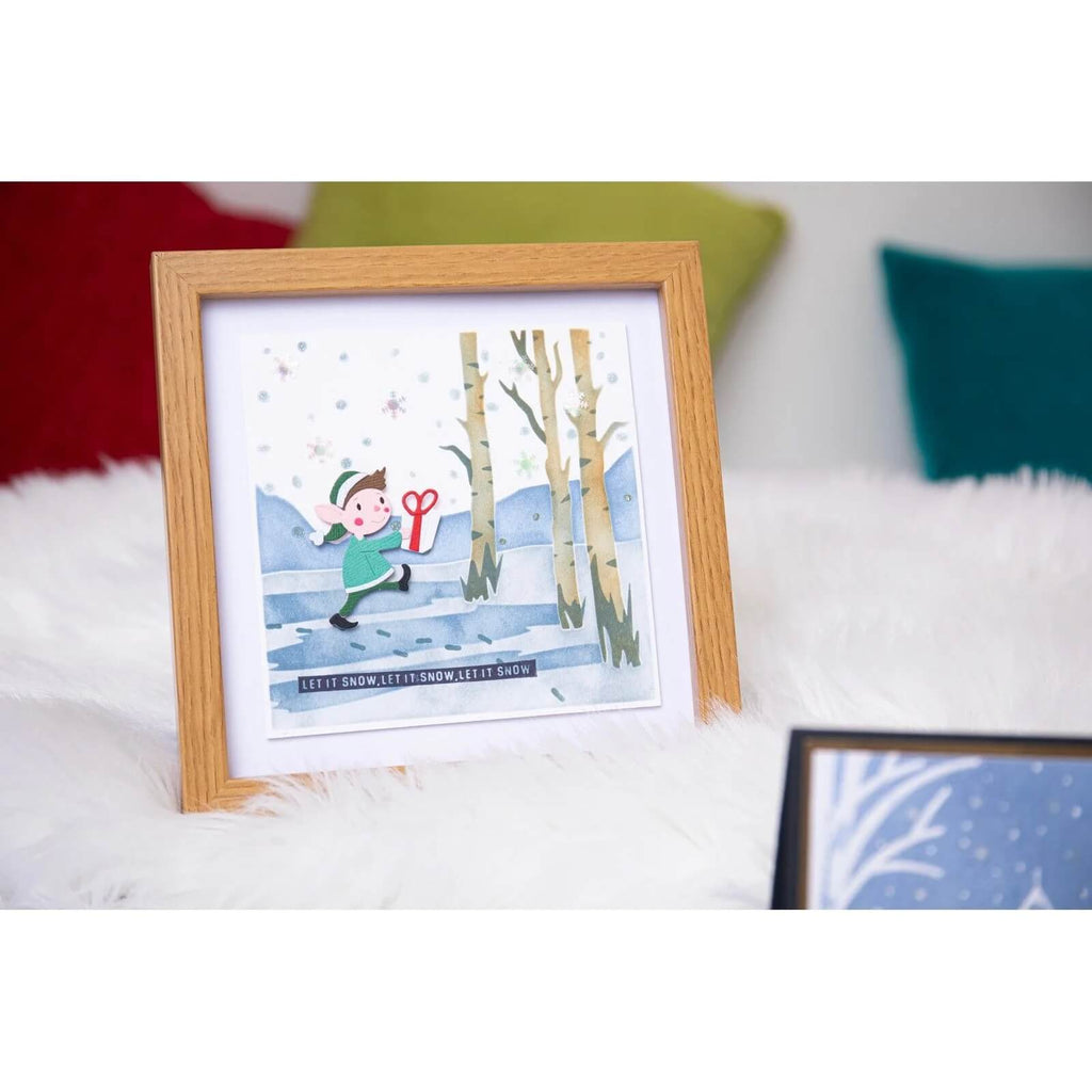Ein gerahmtes Bild eines Jungen, der mit Sizzix im Schnee spielt • Thinlits Die Set Santa & Elves.