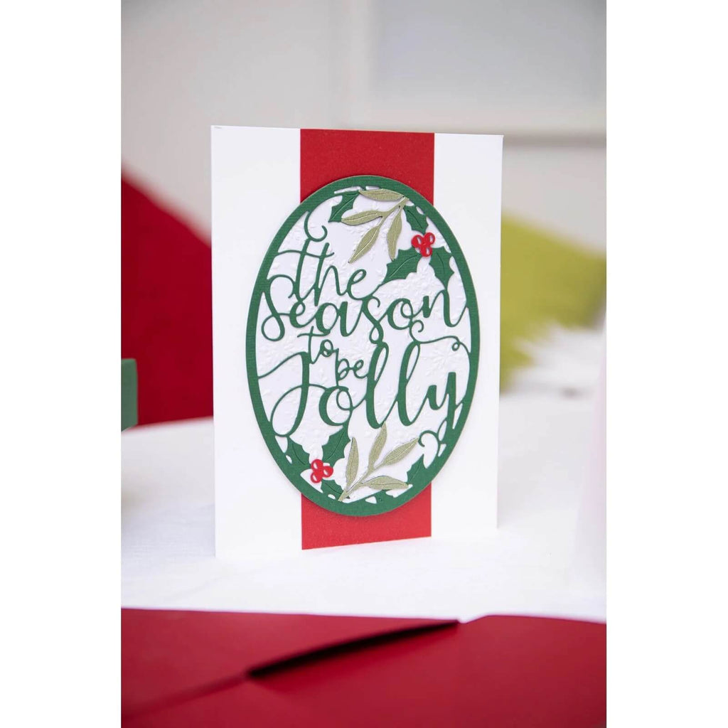 Eine Sizzix • Thinlits Die Set Jolly Season-Weihnachtskarte, verziert mit Stechpalmenblättern.