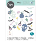 Die gestanzten Formen aus dem Set Sizzix 666453 - Thinlits Spooky Icons - Totenköpfe, Fledermäuse, Blumen, ein Hexenhut und Zaubertrankflaschen - sind auf einem weißen Hintergrund angeordnet. Auf der Verpackung steht "Sizzix" und der Hinweis, dass es 15 Stanzformen gibt.