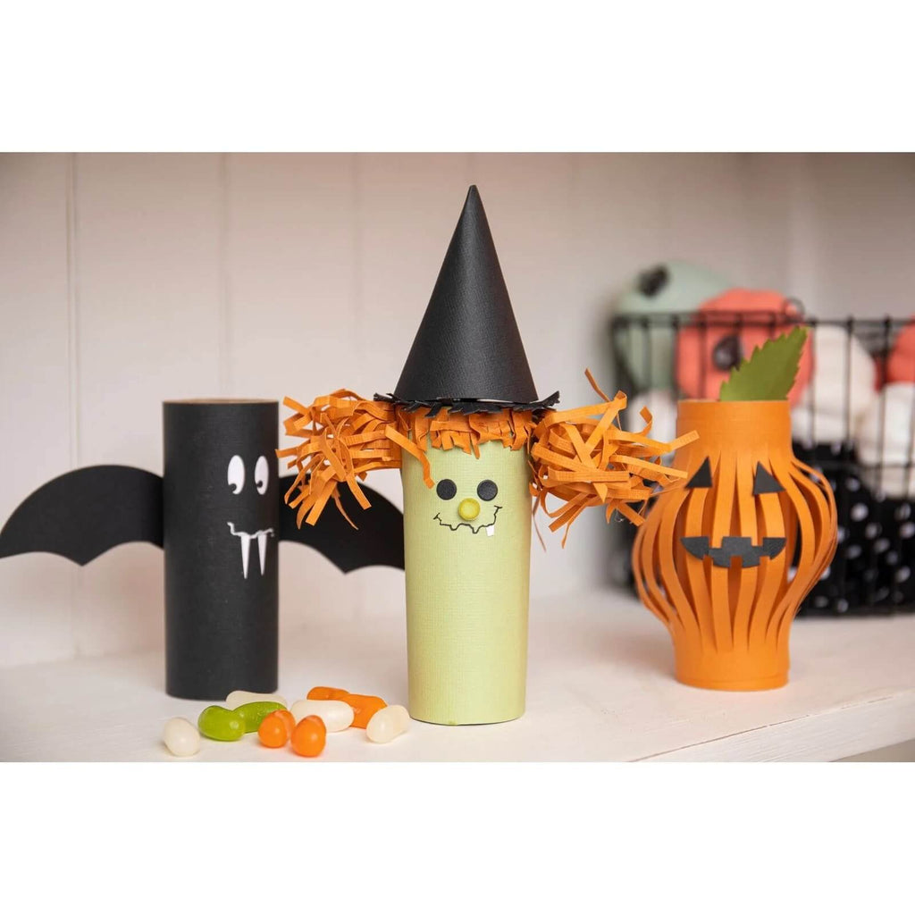 Drei Halloween Sizzix Thinlits Die Set 3D-Laternen-Toilettenpapierrollen mit Hexen und Kürbissen darauf.