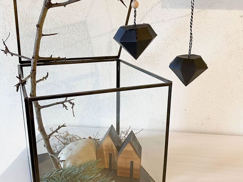Ein Weihnachtsbaum im Glasbehälter mit schwarzen Ornamenten und einer Stanzschablone Kleine Diamantschachtel von Stanzenshop.de.