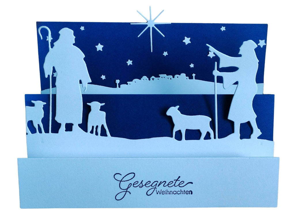 Eine Weihnachtskarte mit der Silhouette von Jesus und seinen Schafen, erstellt mit einer Stanzschablone Hirten von Stanzenshop.de, ein wunderschönes Bastelergebnis.