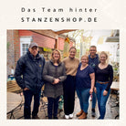Sechs Leute von Stanzenshop.de lächeln im Freien für ein Gruppenfoto. Der Schriftzug "Das Team hinter STANZENSHOP.DE" steht darüber. Tische und Stühle zeigen ihre Liebe zum Basteln und Scrapbooking, mit Produkten wie der Stanzschablone: Eule mit abstehenden Ohren.
