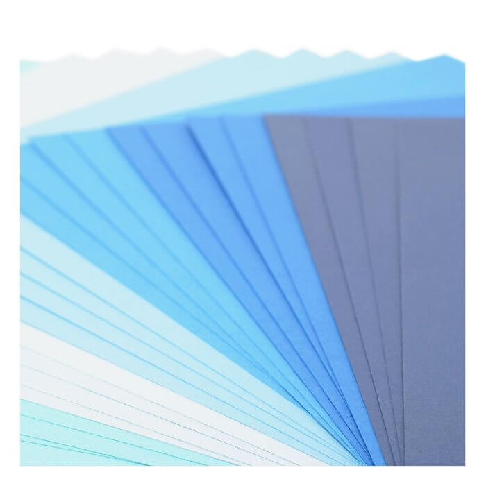 Ein aufgefächerter Stapel Florence - Cardstock Multipack Textur 30,5x30,5cm Blau Blätter in verschiedenen Blautönen - von hell bis dunkel - ideal für Scrapbooking-Projekte.