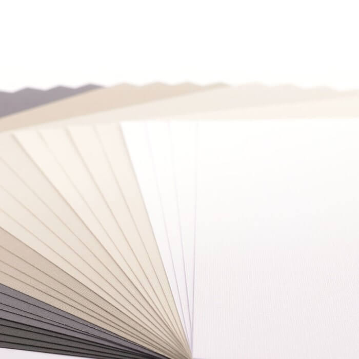 Ein Stapel Florence • Cardstock-Multipack-Textur in 30,5x30,5cm Schwarz auf weißem Hintergrund.
