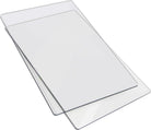 Zwei transparente Sizzix Acrylplatten Cutting Pad Big Shot™ Standard 15 x 22,5 cm sind leicht schief auf einem weißen Hintergrund gestapelt.