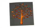 Eine quadratische schwarze Karte mit Baum-, Blüten- und Blattausschnitten leuchtet in orangefarbenem Licht - ideal für Scrapbooking oder Basteln mit der "Stanzschablone Baum mit Blüten und Blättern" von Stanzenshop.de.