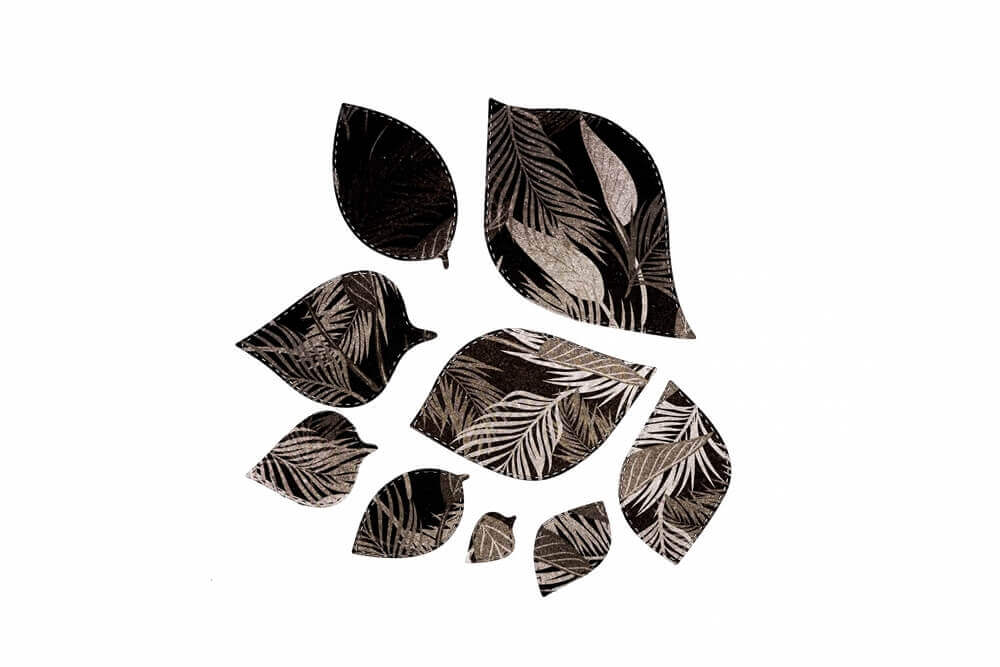 Neun blattförmige Ausschnitte, hergestellt mit der "Stanzschablone: Blätter in verschiedenen Größen" von Stanzenshop.de, zeigen ein monochromes botanisches Muster und sind auf weißem Hintergrund angeordnet - eine Inspiration für Bastelprojekte.