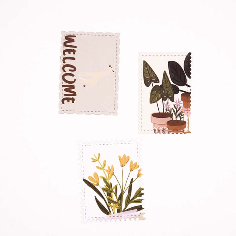 Ein Set Stanzschablone Drei Briefmarken, Verzierung, Rahmen, Kleben, Stempel-Grußkarten mit Pflanzen und einem Willkommensschild von Stanzenshop.de.