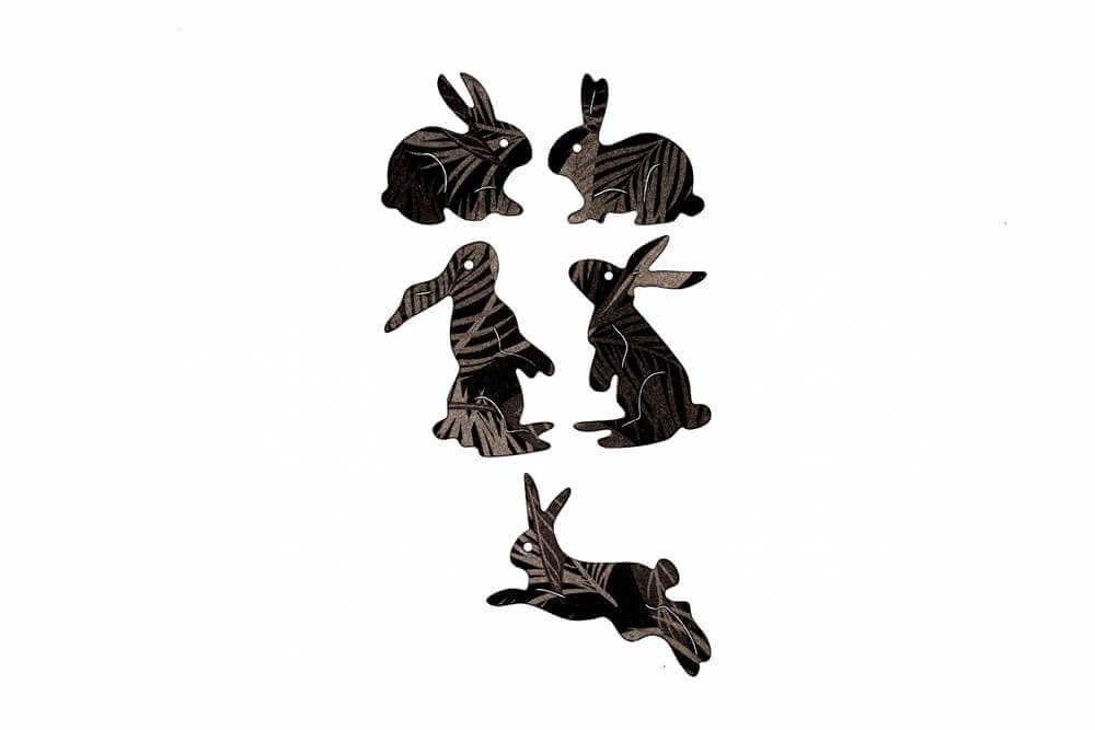 Die "Stanzschablone: Fünf verschiedene Hasen" von Stanzenshop.de bietet fünf schwarze, gemusterte Hasen-Silhouetten in verschiedenen Posen auf weißem Hintergrund - ideal zum Basteln oder für Stanzarbeiten.