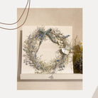 Die "Stanzschablone Fünf verschiedene Äste" von Stanzenshop.de, ideal zum Basteln oder Scrapbooking, setzt einen charmanten Akzent auf einem weißen Regal vor einer hellen Wand.