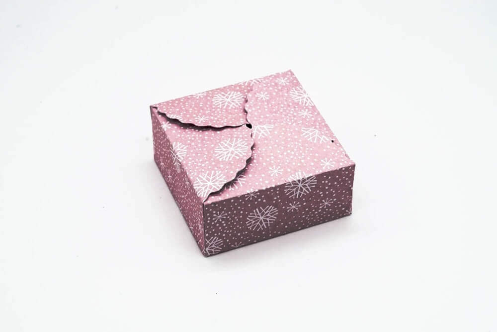 Modifizierte Beschreibung: Eine rosa Stanzschablone als Geschenkkästchen mit einer rosa Blume darauf.