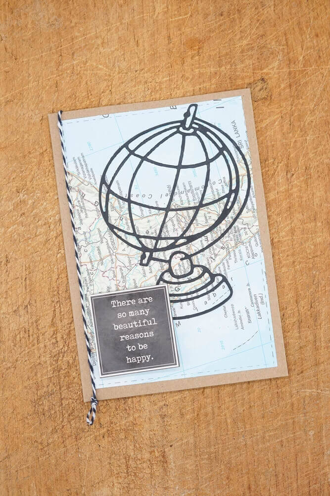 Handgefertigte Grußkarte mit Stanzschablone: Großer Globus-Design und inspirierendem Zitat auf Holzhintergrund von Stanzenshop.de.