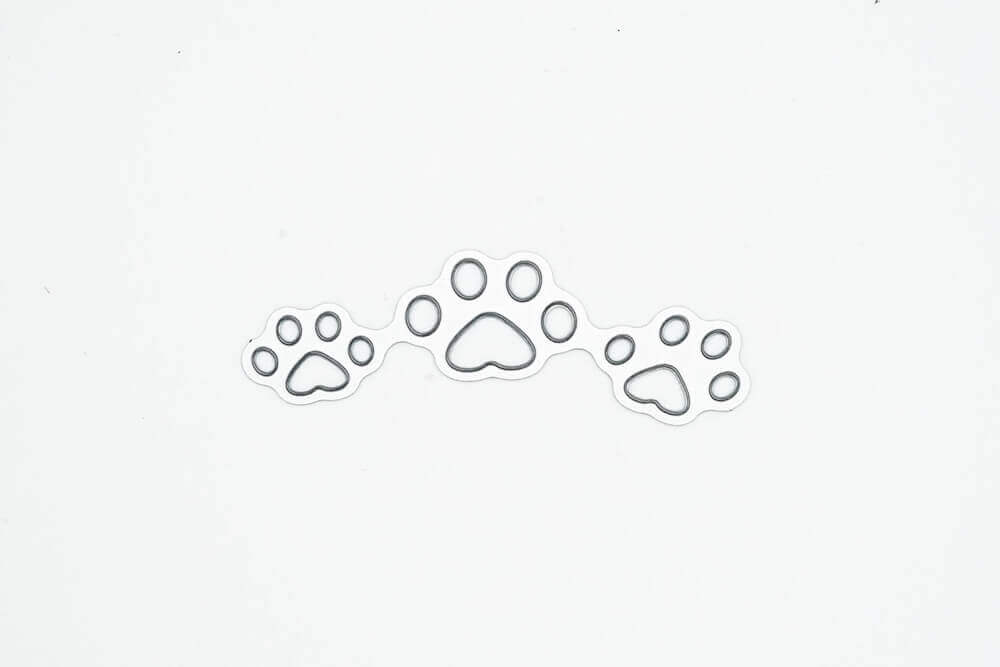 Drei Pfotenabdrücke auf Stanzschablone Hundepfoten von Stanzenshop.de auf hochwertigem Papier.