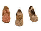 Drei handgefertigte, gewebte Babyschuhe mit perforierten Mustern sind auf weißem Hintergrund abgebildet - links rosa, in der Mitte strohgelb, rechts beige - eine ideale Inspiration für Ihre Projekte mit der Stanzschablone Kinderschuh für ein Baby von Stanzenshop.de.