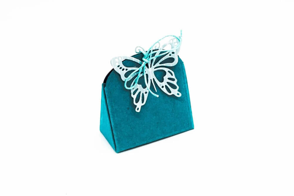 Eine blaugrüne Geschenktüte mit einem Schmetterling darauf ist ein echter Hingucker. Stanzschablone Kleine Tischkarte Schachtel von Stanzenshop.de.