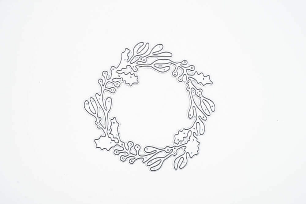 Die "Stanzschablone: Kranz mit Beeren" von Stanzenshop.de ist eine zarte Metallic-Kranzstanze mit Stechpalmenblättern und Beeren - ideal zum Basteln oder Scrapbooking - auf einem schlichten weißen Hintergrund.