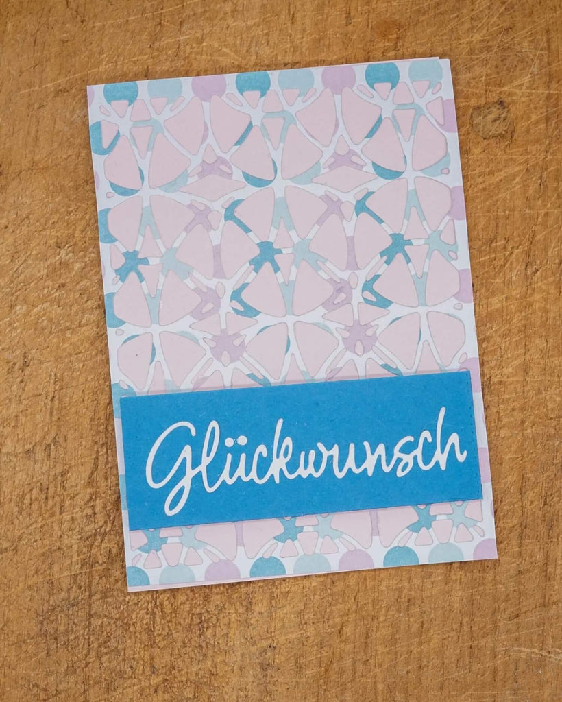 Eine blau-weiße Stanzschablone: Platte mit Kreismuster mit dem Wort glückenrunch darauf von Stanzenshop.de.