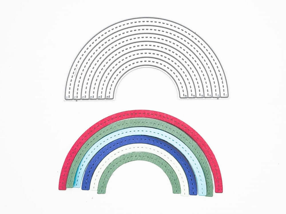 Die Stanzschablone Regenbogen von Stanzenshop.de liegt auf einem fertigen Bastelprojekt: ein bunter Regenbogen aus Papier auf weißem Hintergrund - kompatibel mit vielen Stanzmaschinen.