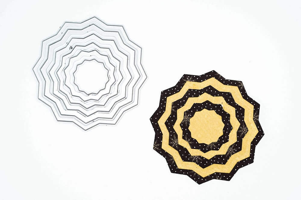 Die Stanzschablone: Rosette 6-teilig von Stanzenshop.de hat zwei konzentrische, zickzackförmige Formen mit silbernen und mehrfarbigen Mustern - perfekt zum Basteln und kompatibel mit Big Shot Maschinen.