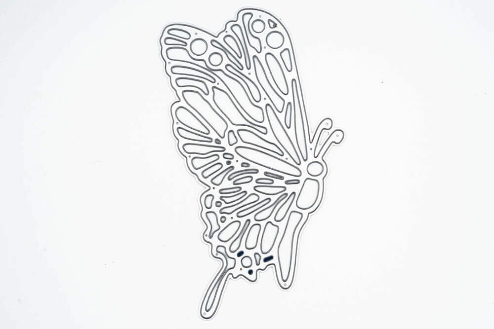 Die Stanzschablone "Schmetterling mit großen Flügeln" von Stanzenshop.de ist eine detaillierte Stanzschablone aus Metall mit durchbrochenen Flügeln, ideal für Karten basteln oder Scrapbooking, abgebildet auf einem schlichten weißen Hintergrund.