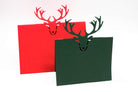 Die Stanzschablone: Tischkarte Rentierkopf von Stanzenshop.de zaubert rote und grüne Klappkarten mit einem Rentierkopf-Ausschnitt - ideal für Tischkarten basteln oder kreative Scrapbooking-Projekte.