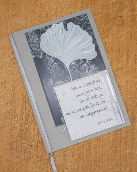 Eine Kondolenzkarte verziert mit der Stanzenshop.de Stanzschablone Zwei Ginkgoblätter und einem Goethe-Zitat auf der Vorderseite, platziert auf Holz - ideal zum Basteln oder für Scrapbooking-Projekte.