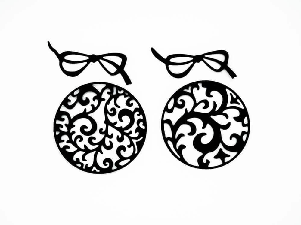 Zwei runde Zwei Weihnachtskugeln mit dekorativen Wirbeln im Brillengestell von Stanzenshop.de.