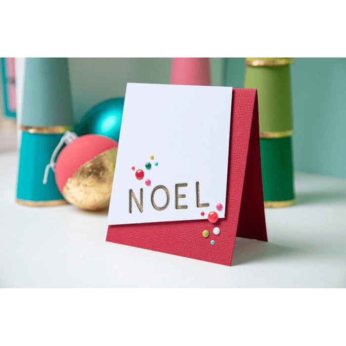 Eine Sizzix-Weihnachtskarte mit dem Wort „Noel“ darauf.
