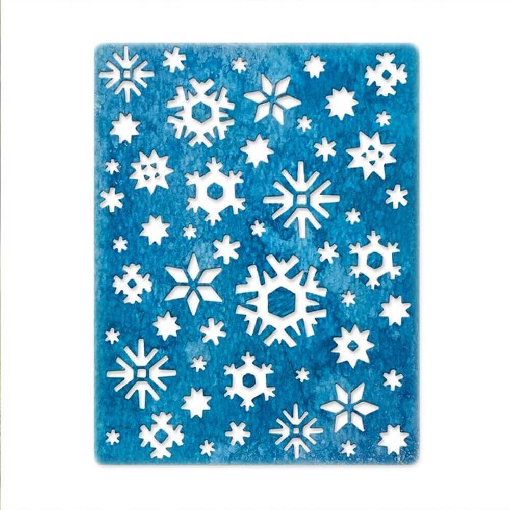 Ein blauer Hintergrund mit Schneeflocken, hergestellt mit Stanzschablonen der Marke Sizzix.