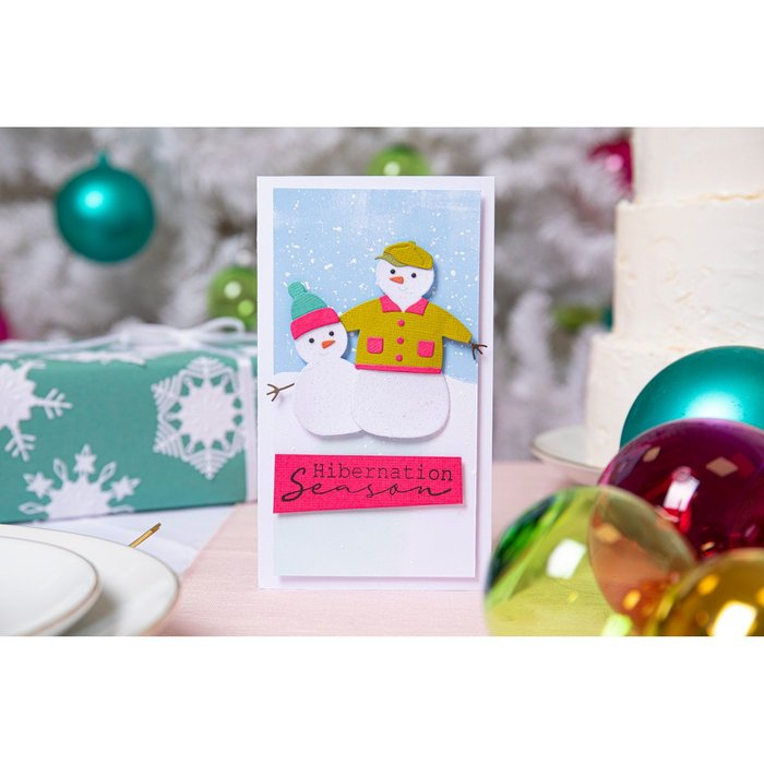 Eine Sizzix-Weihnachtskarte mit einer Schneefamilie darauf.