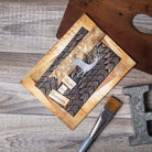 Eine handgefertigte Karte mit einem Metallhirsch aus den Sizzix 664968 Thinlits 4PK Darling Deer von Tim Holtz zeigt einen geometrischen Hintergrund und "Trau dich zu träumen", dargestellt auf Holz neben einem Pinsel und dem Metallbuchstaben H. Marke: Sizzix.